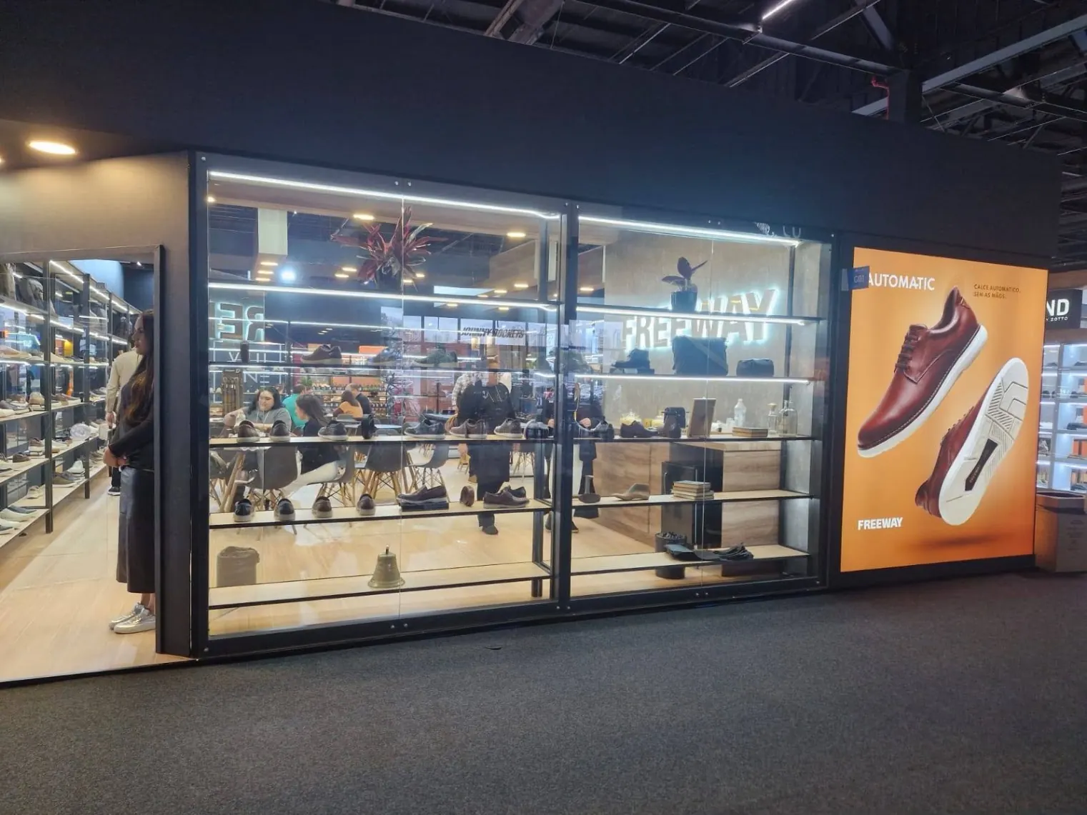 Fachada de stand construído com vitrine em vidro e iluminação LED